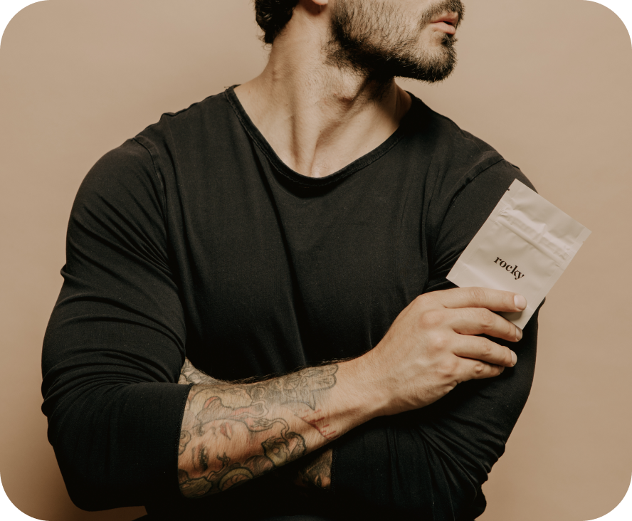 A man holding a beige package with the text 'rocky' on it.